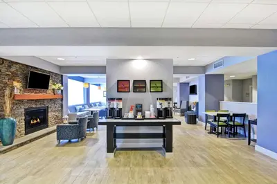 a lobby with a fireplace and tables and chairs at Hampton Inn Sayre in Sayre
