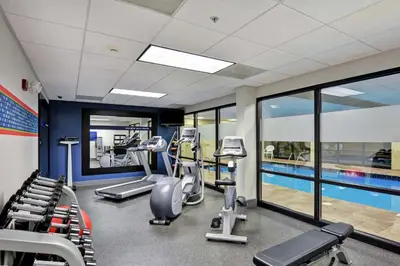 a gym with treadmills and a swimming pool at Hampton Inn Sayre in Sayre