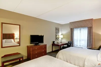 a hotel room with two beds and a television at Hampton Inn Sayre in Sayre