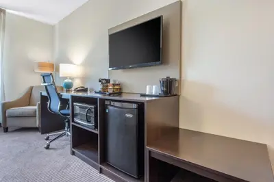 a hotel room with a desk and a tv at Sleep Inn & Suites Monroe - Woodbury in Monroe