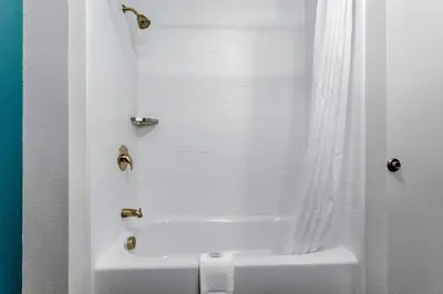 a bathroom with a white tub and a shower at Sleep Inn & Suites Monroe - Woodbury in Monroe