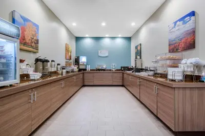 a restaurant with wooden cabinets and a food counter at Sleep Inn & Suites Monroe - Woodbury in Monroe