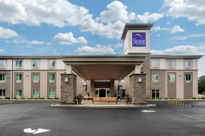 a hotel with a sign on the front of it at Sleep Inn & Suites Monroe - Woodbury in Monroe