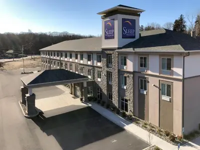 a large building with a sign on top of it at Sleep Inn & Suites Monroe - Woodbury in Monroe