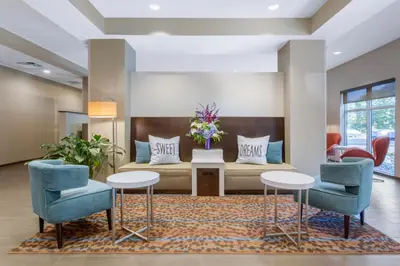 a lobby with a couch and two chairs at Sleep Inn & Suites Monroe - Woodbury in Monroe