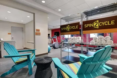 a gym with blue chairs and a rack of weights at Home2 Suites By Hilton Bordentown in Bordentown