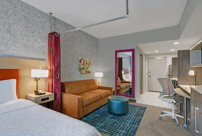 a hotel room with a bed and a living room at Home2 Suites By Hilton Bordentown in Bordentown