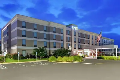 an office building with an american flag in a parking lot at Home2 Suites By Hilton Bordentown in Bordentown