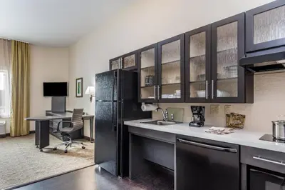 a kitchen with a black refrigerator and a desk at Candlewood Suites Bethlehem South by IHG in Bethlehem