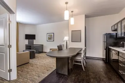 a living room with a table and a kitchen at Candlewood Suites Bethlehem South by IHG in Bethlehem