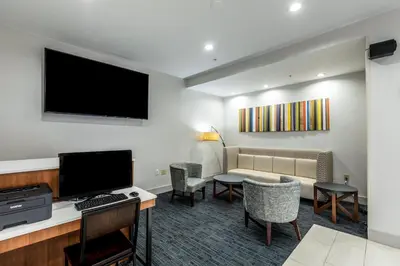 a hotel room with a couch and a television at Holiday Inn Express & Suites Jersey City North - Hoboken by IHG in Jersey City