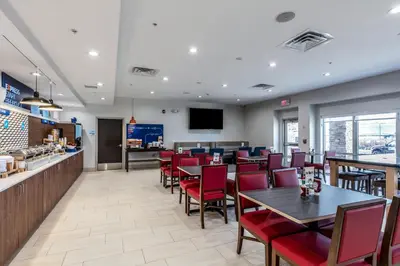 a restaurant with tables and chairs and a bar at Holiday Inn Express & Suites Jersey City North - Hoboken by IHG in Jersey City