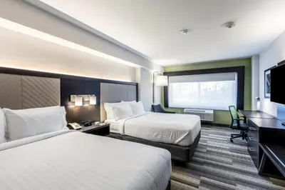 a hotel room with two beds and a flat screen tv at Holiday Inn Express & Suites Jersey City North - Hoboken by IHG in Jersey City