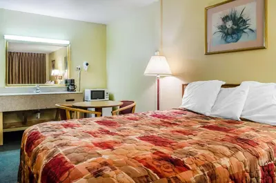 a hotel room with a bed and a bathroom at Relax Inn in Lewisburg