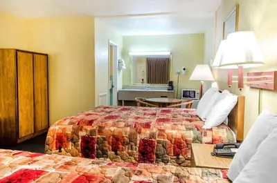 a hotel room with two beds and a bathroom at Relax Inn in Lewisburg