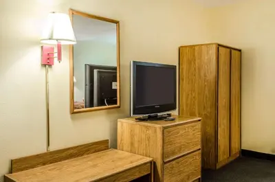 a room with a television on a dresser with a mirror at Relax Inn in Lewisburg