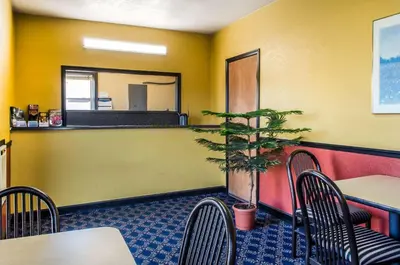 a restaurant with a table and chairs and a potted plant at Relax Inn in Lewisburg