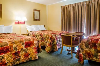 a hotel room with two beds and a table at Relax Inn in Lewisburg