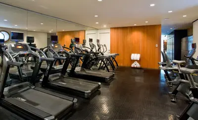a gym with rows of cardio equipment in a room at Dream Downtown, by Hyatt in New York