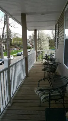 a porch with benches and tables on a house at Hotel Belvidere in Belvidere
