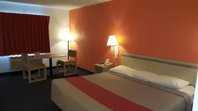 a hotel room with a bed and a desk at Red Carpet Inn in Gibbstown