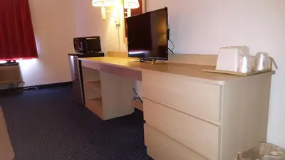 a hotel room with a desk with a computer on it at Red Carpet Inn in Gibbstown