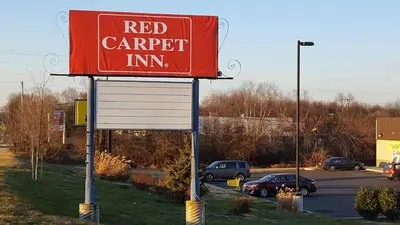 a red carpet inn sign in a parking lot at Red Carpet Inn in Gibbstown