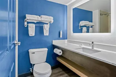 a bathroom with a sink and a toilet and a mirror at Spark by Hilton Mechanicsburg in Mechanicsburg
