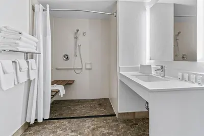 a white bathroom with a sink and a shower at Spark by Hilton Mechanicsburg in Mechanicsburg