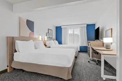 a hotel room with two beds and a desk at Spark by Hilton Mechanicsburg in Mechanicsburg