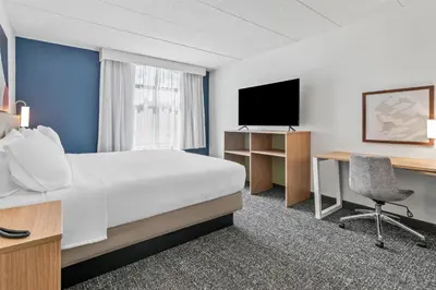 a hotel room with a bed and a desk and a tv at Spark by Hilton Mechanicsburg in Mechanicsburg