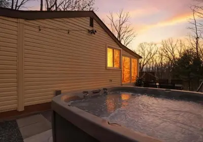 a hot tub in the backyard of a house at Pocono cabin with hot tub and private pool at Shawnee Mtn in East Stroudsburg