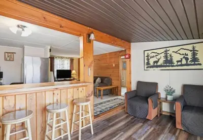 a living room with a bar and two stools at Pocono cabin with hot tub and private pool at Shawnee Mtn in East Stroudsburg