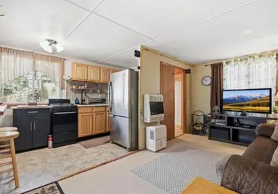 a kitchen with a stainless steel refrigerator and a tv at Pocono cabin with hot tub and private pool at Shawnee Mtn in East Stroudsburg