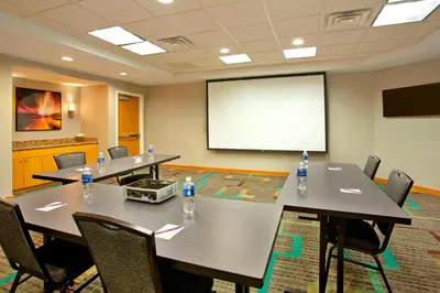 a conference room with tables and chairs and a white screen at Residence Inn Bridgewater Branchburg in Branchburg Park