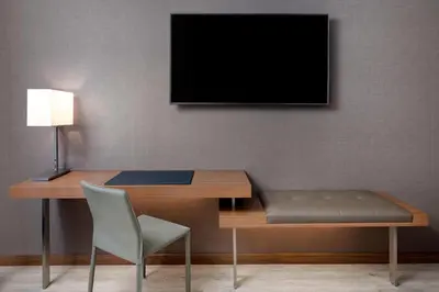 a desk with a chair and a television on a wall at AC Hotel by Marriott New York Downtown in New York