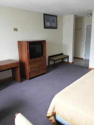 a hotel room with a bed and a television at Village Motel in Ellenville