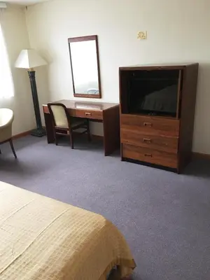 a hotel room with a television and a desk at Village Motel in Ellenville