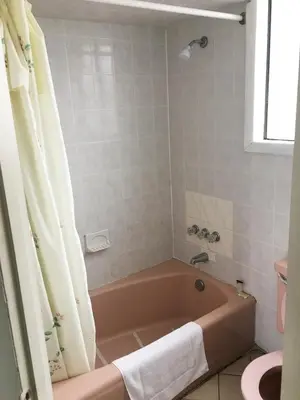 a bathroom with a bath tub and a toilet at Village Motel in Ellenville