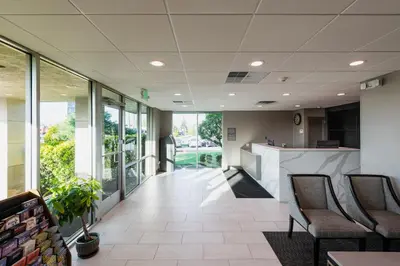 an office lobby with chairs and a counter at Garden Executive Hotel in South Plainfield