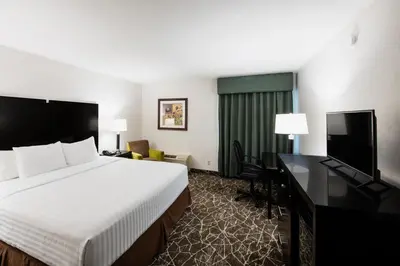 a hotel room with a bed and a flat screen tv at Garden Executive Hotel in South Plainfield