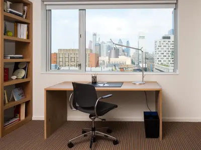 an office with a desk with a window and a chair at The Study at University City, Study Hotels in Philadelphia