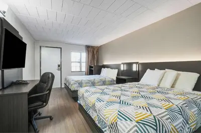 a hotel room with two beds and a desk at Motel 6 Carlisle, PA - Cumberland Valley in Carlisle