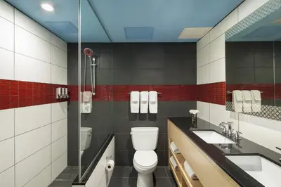 a bathroom with a toilet and two sinks at TRYP by Wyndham New York City Times Square - Midtown in New York