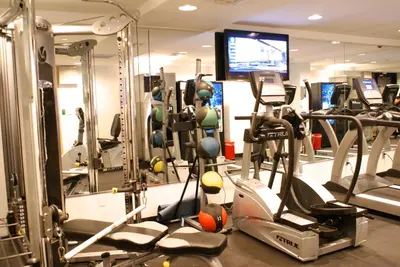 a gym with several tread machines and a tv at TRYP by Wyndham New York City Times Square - Midtown in New York
