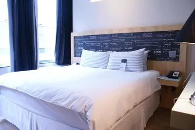 a bedroom with a white bed with a chalkboard on the wall at TRYP by Wyndham New York City Times Square - Midtown in New York
