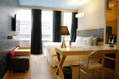 a hotel room with a bed and a desk with a desk at TRYP by Wyndham New York City Times Square - Midtown in New York