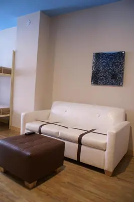 a living room with a white couch and a ottoman at TRYP by Wyndham New York City Times Square - Midtown in New York