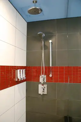 a bathroom with a shower with red and white tiles at TRYP by Wyndham New York City Times Square - Midtown in New York
