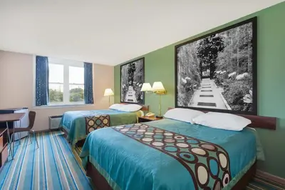 a hotel room with two beds and a desk at Super 8 by Wyndham Harrisburg Hershey West in Harrisburg